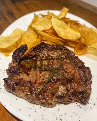 Bife de ancho Angus grelhado, finalizado com ervas e servido com batata