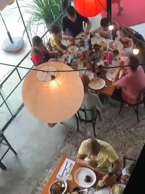 Vista de cima do salão do Mironga cheio, com uma mesa grande de família almoçando